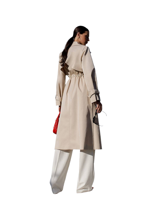 Woman wearing a beige trench coat with a red bag on a white background