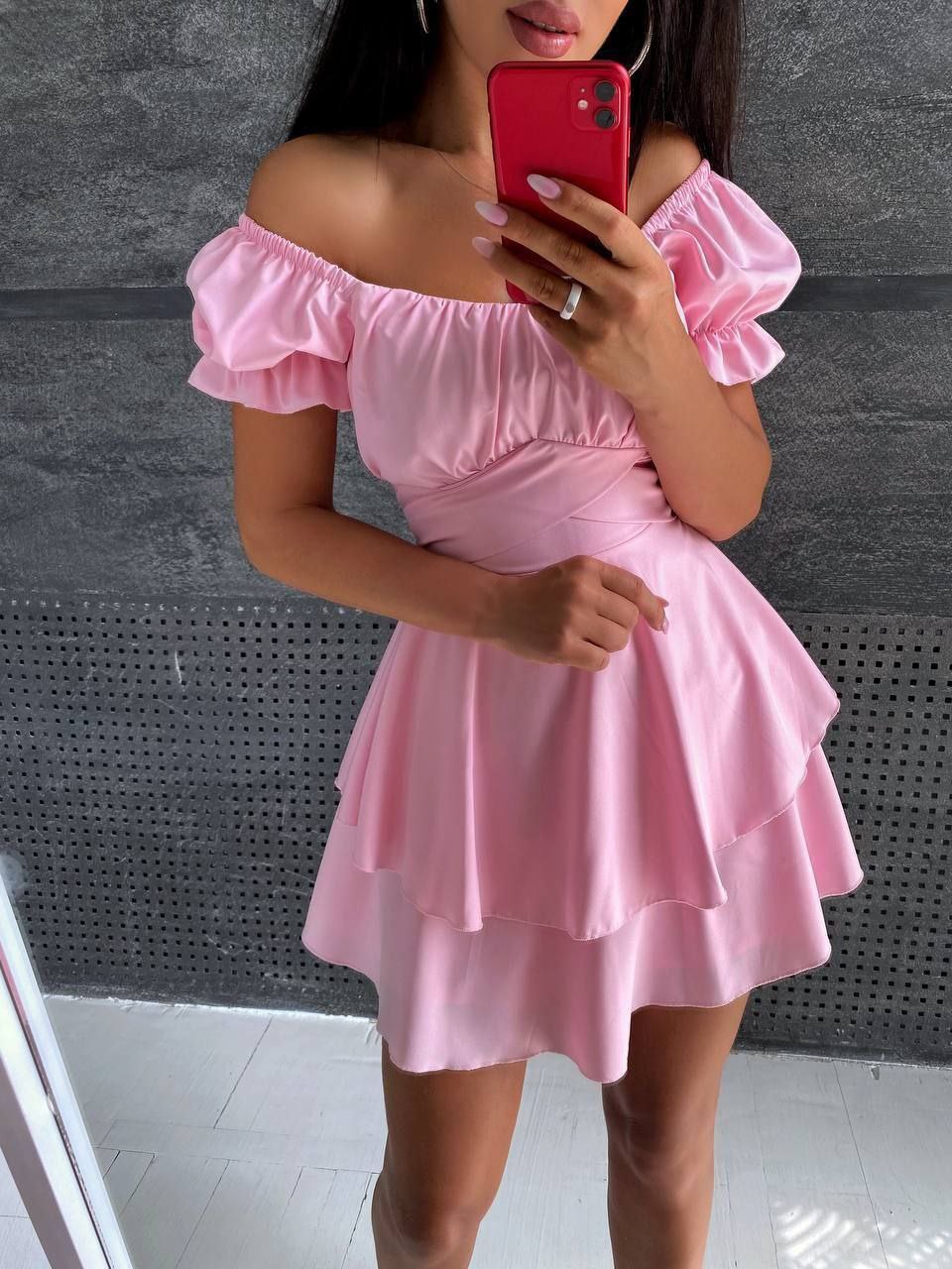 Person wearing a pink off-shoulder dress taking a mirror selfie.
