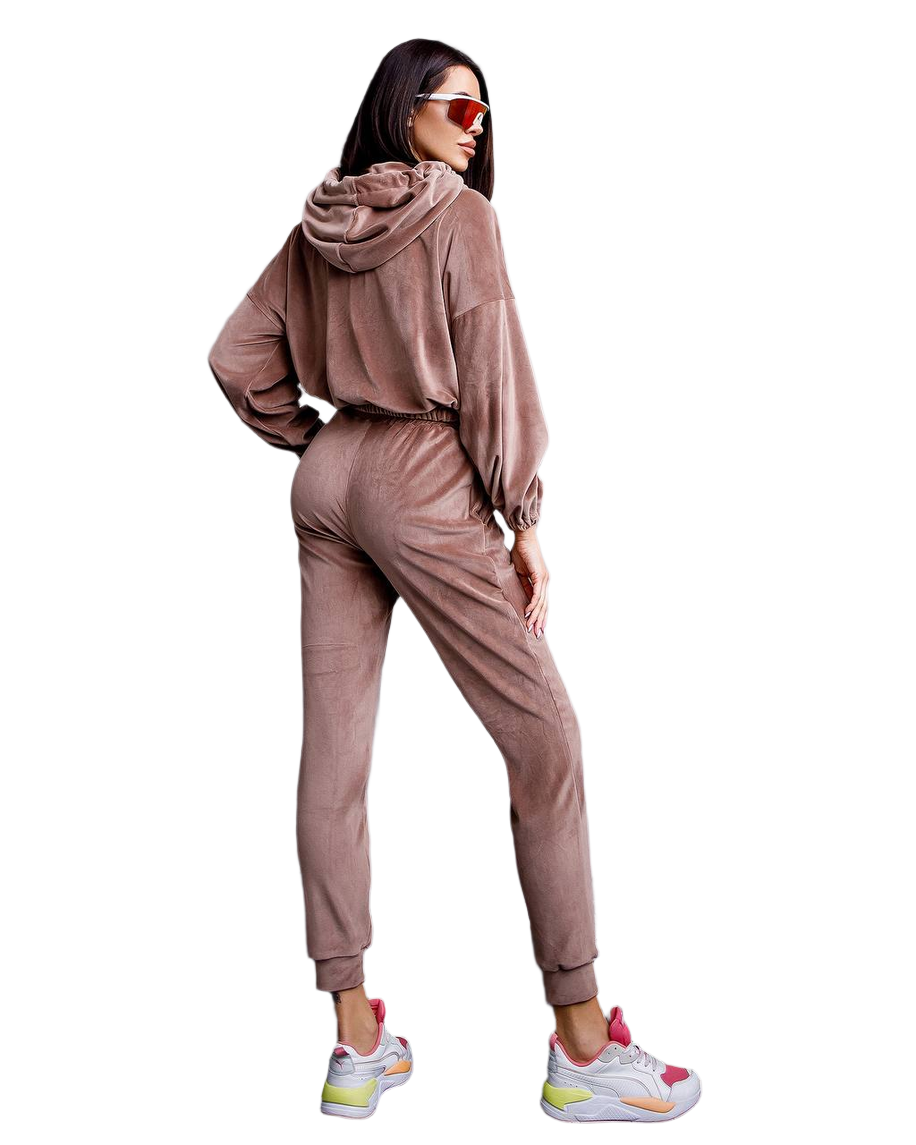 Woman wearing a brown tracksuit with colorful sneakers on a white background