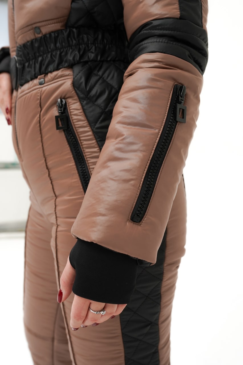 Close-up of a person wearing a brown jacket with black accents on a blurred background