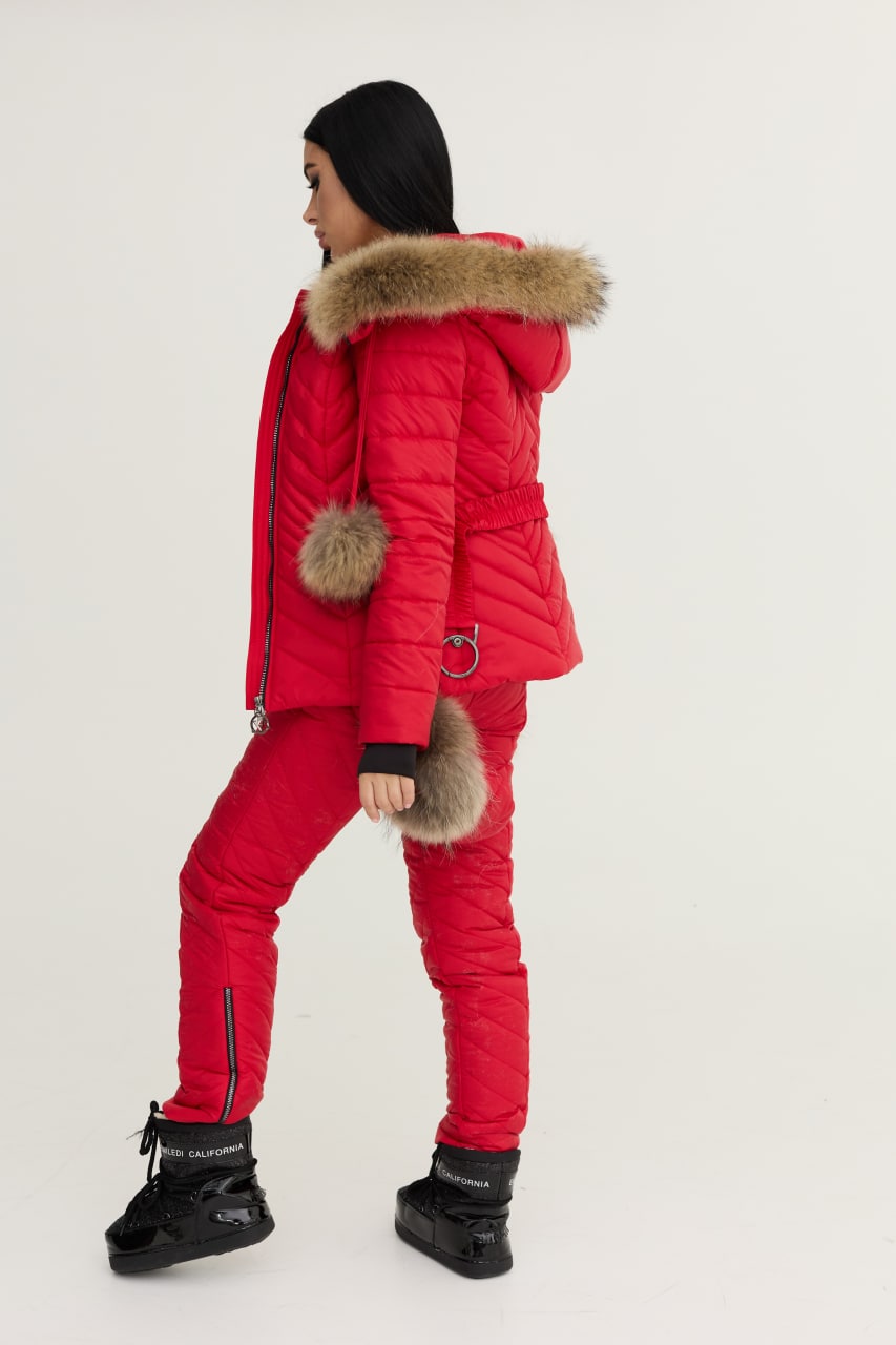 Person wearing a red puffer outfit with fur-lined hood and boots on a white background