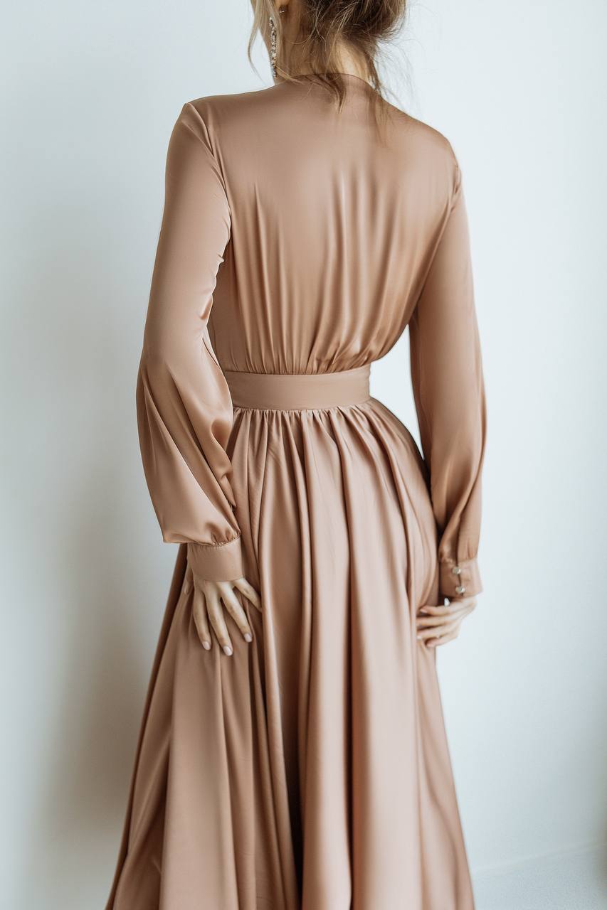 Long beige dress with long sleeves on a plain background