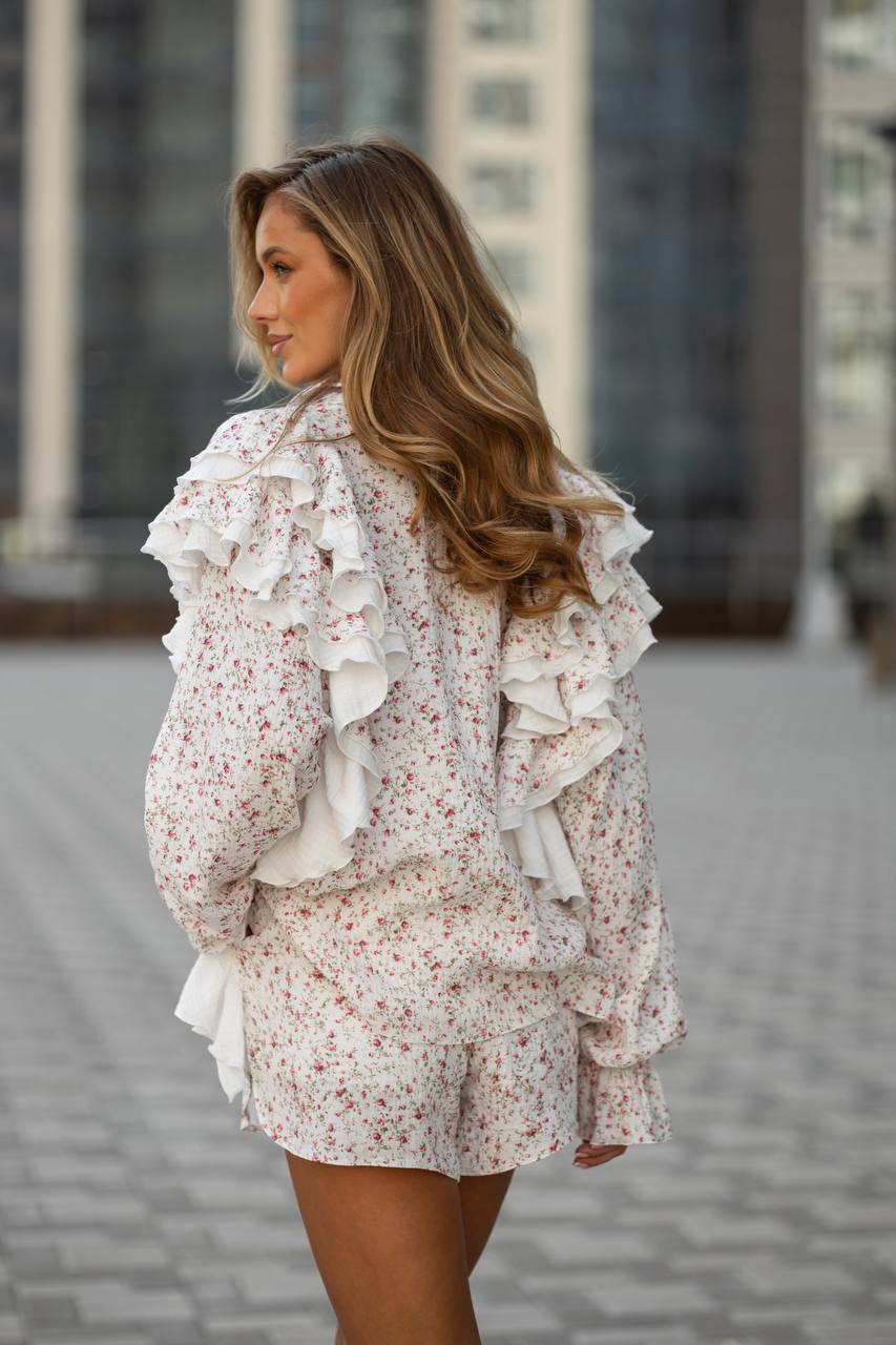 Woman wearing a floral outfit with ruffled details in an urban setting