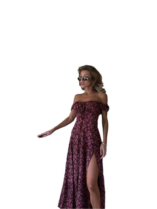 Woman wearing a burgundy off-shoulder dress with a slit on a white background