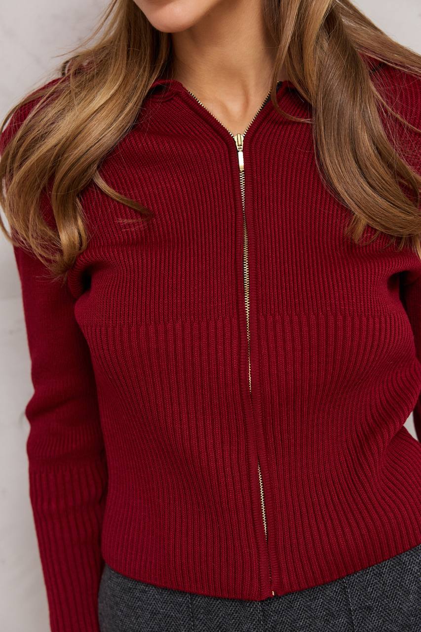 Red ribbed sweater with a zipper worn by a person against a neutral background