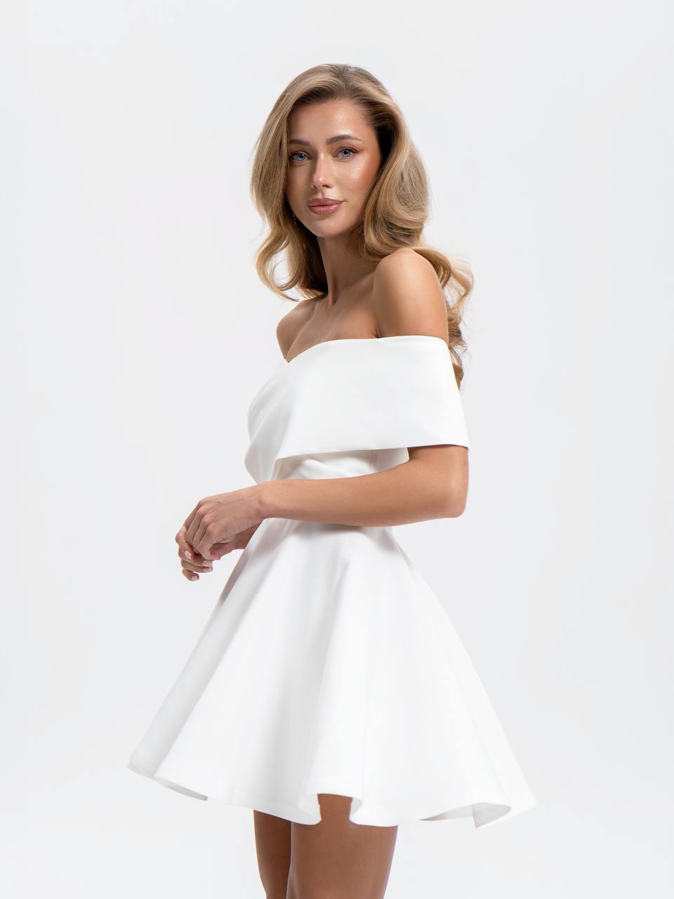 Woman wearing a white off-shoulder dress on a white background