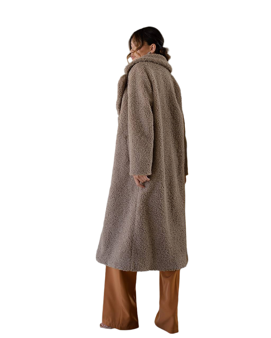 Person wearing a long brown teddy coat on a white background