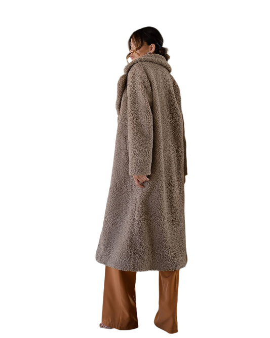 Person wearing a long brown teddy coat on a white background