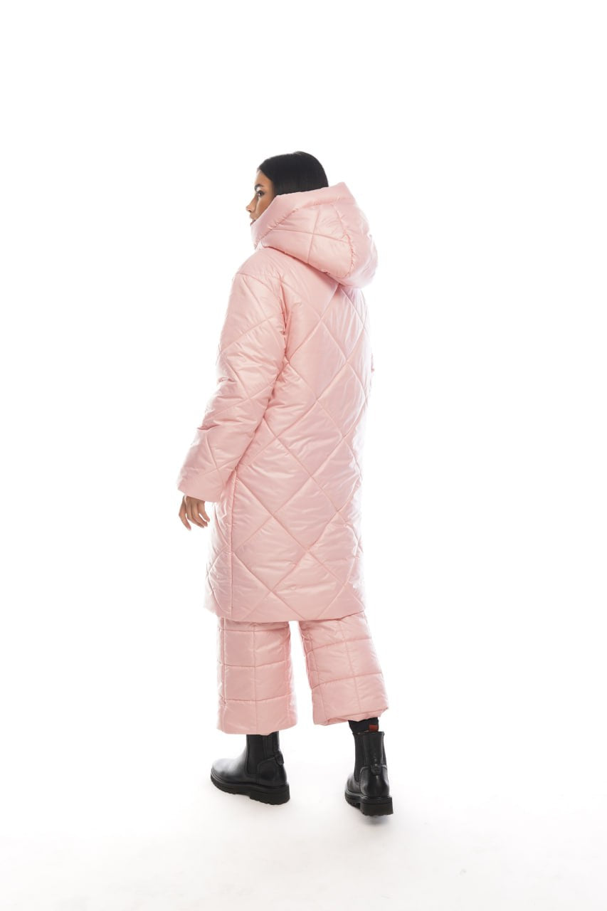 Person wearing a pink quilted coat on a white background