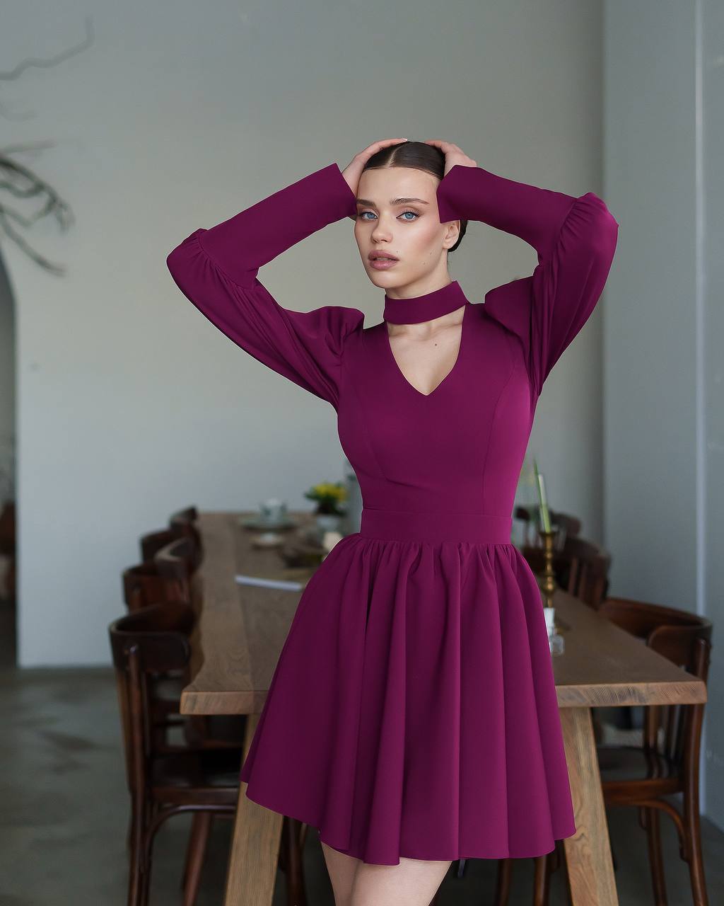 Woman wearing a purple dress in a casual indoor setting