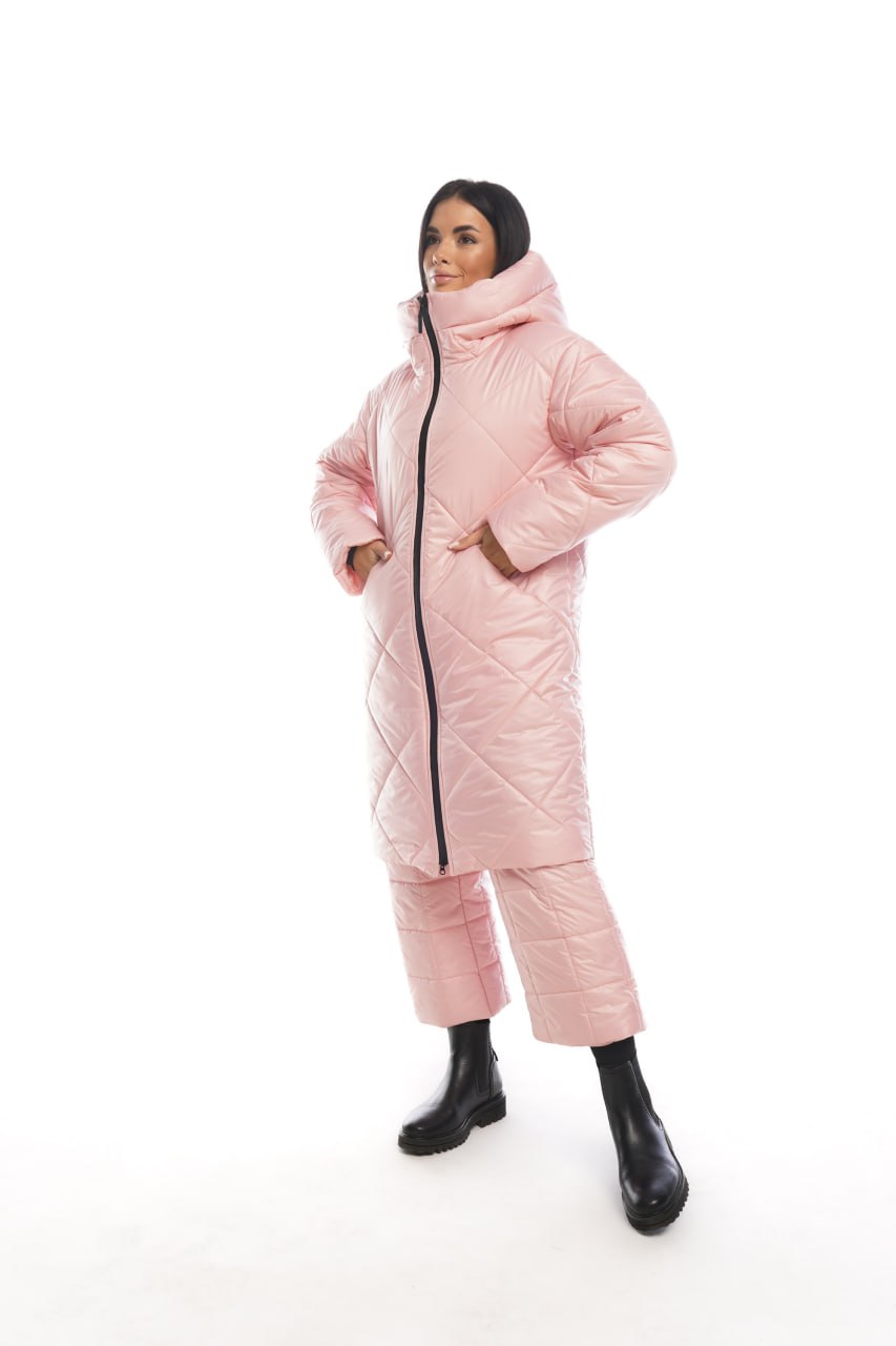 Person wearing a pink quilted jacket and pants on a white background