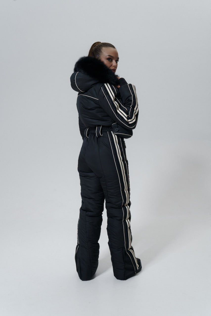 Person wearing a black snowsuit with white stripes on a white background