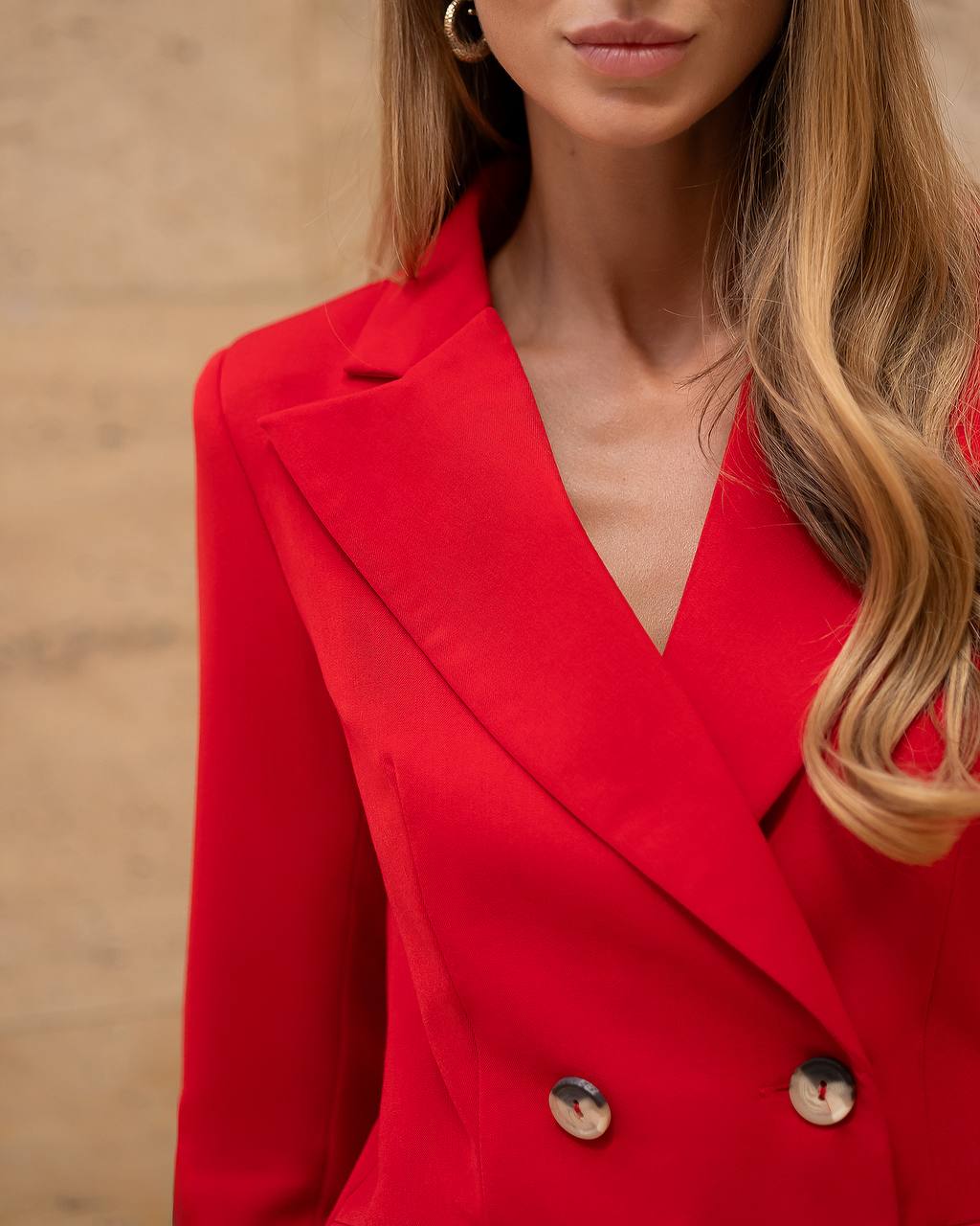 Red blazer worn by a person with a neutral background