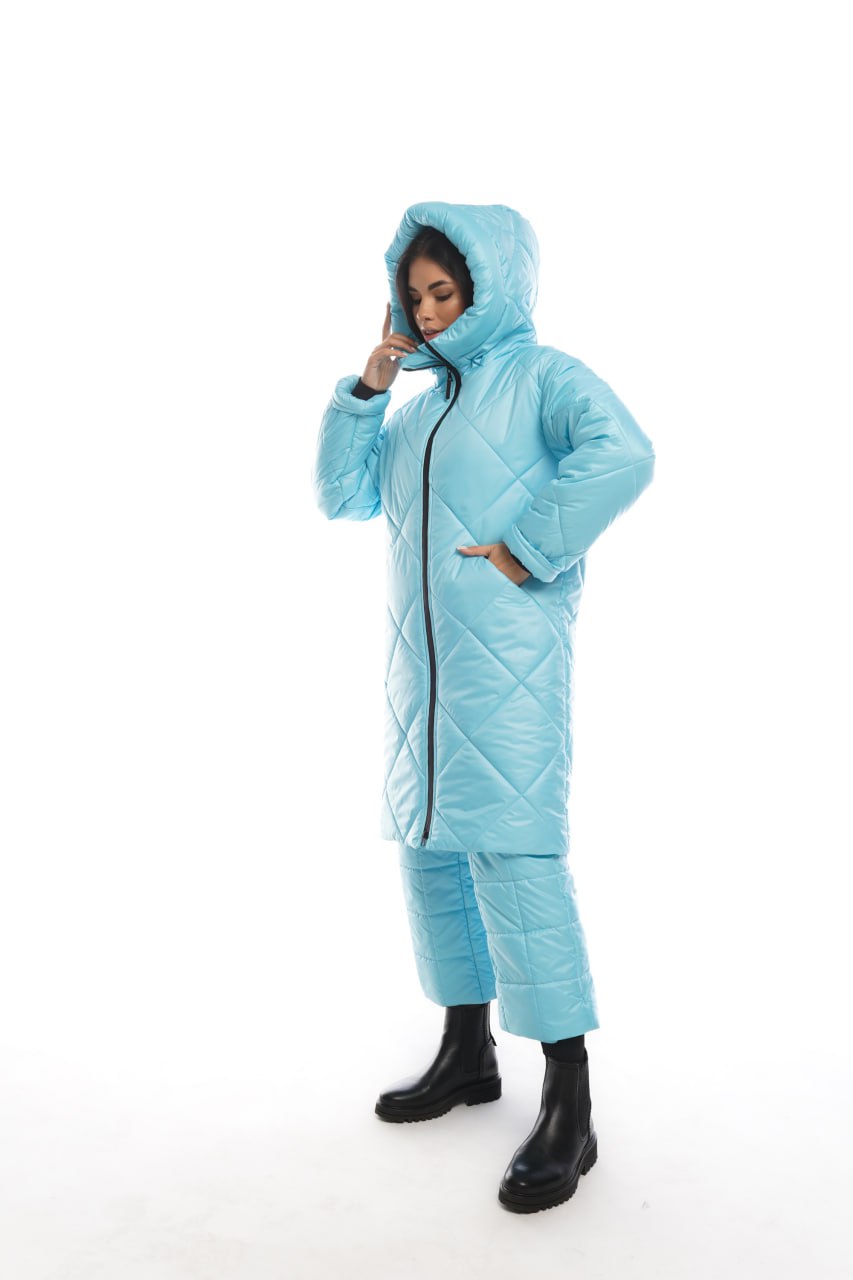 Person wearing a light blue quilted jumpsuit on a white background