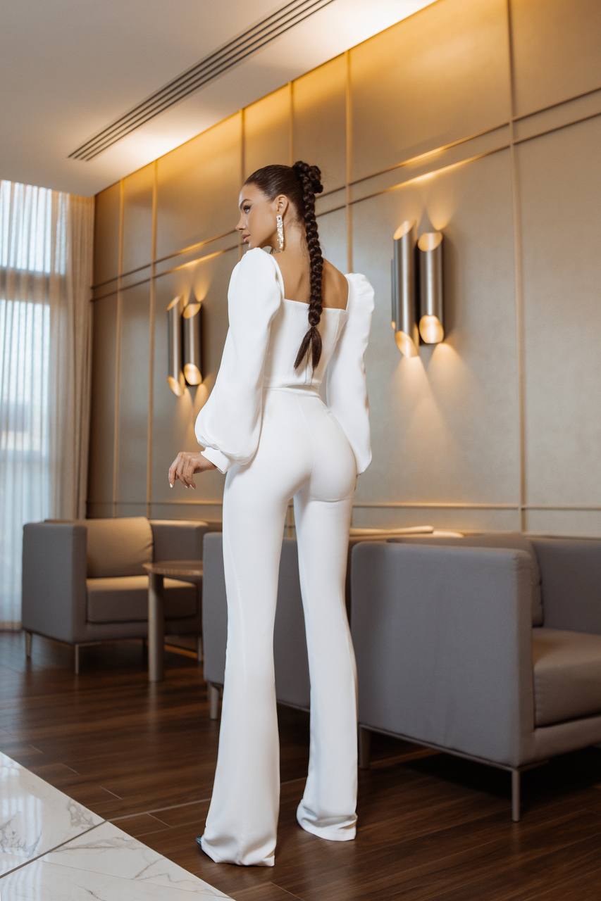 Woman in a white outfit standing in a modern interior setting