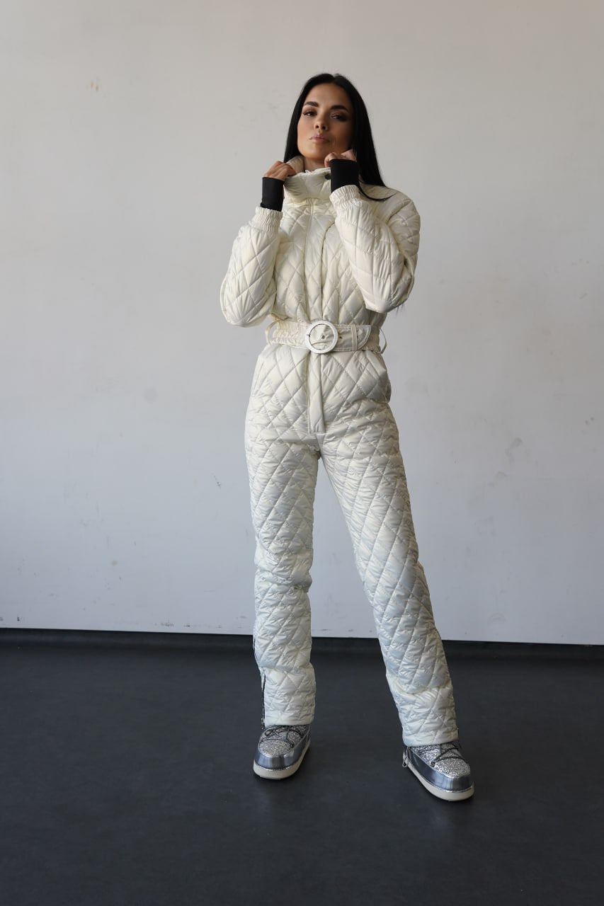 Person wearing a white quilted snowsuit against a plain background