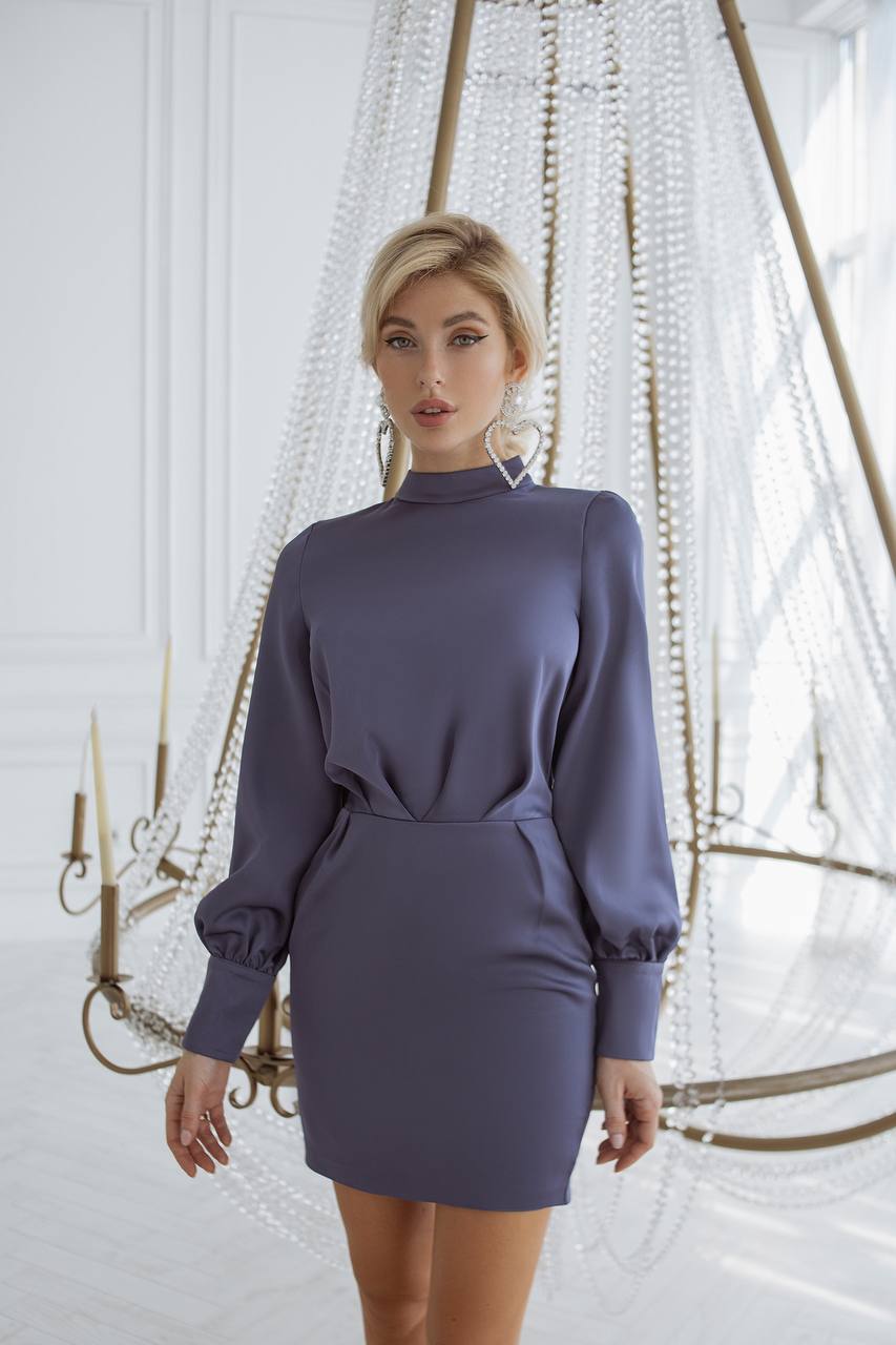 Woman wearing a long-sleeve dress in a decorative indoor setting