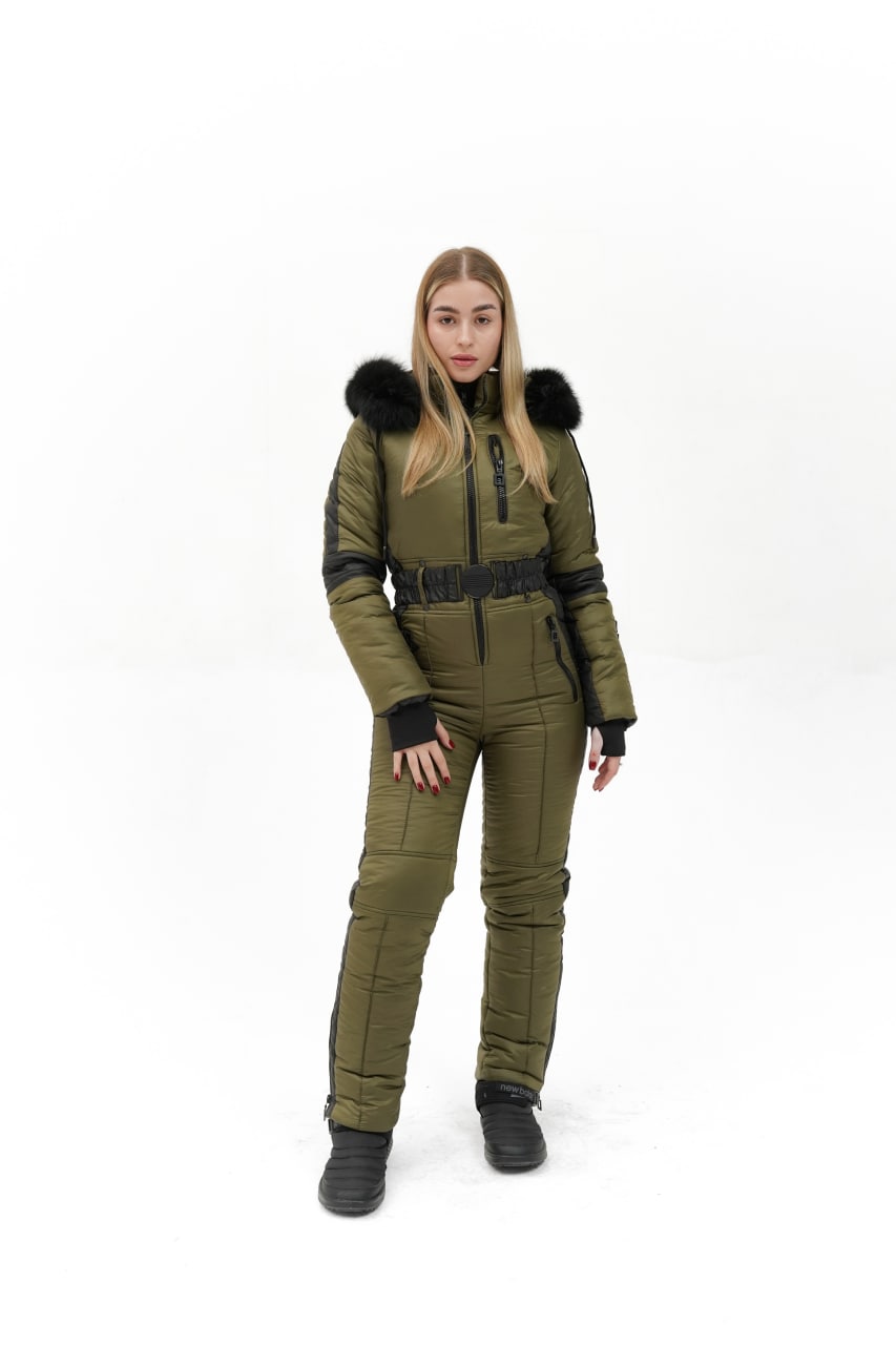 Person wearing a green snowsuit with black fur trim on a white background