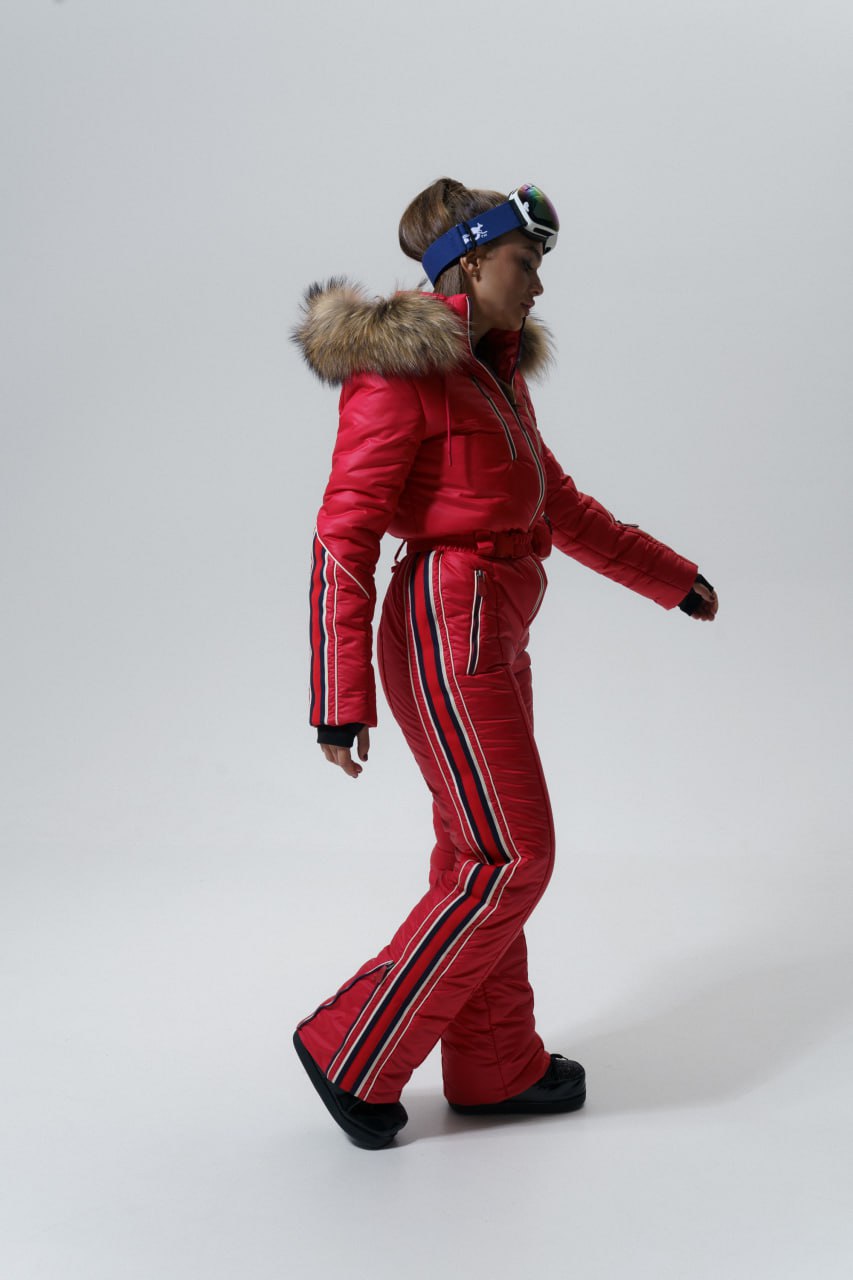Person wearing a red ski suit with fur hood on a white background