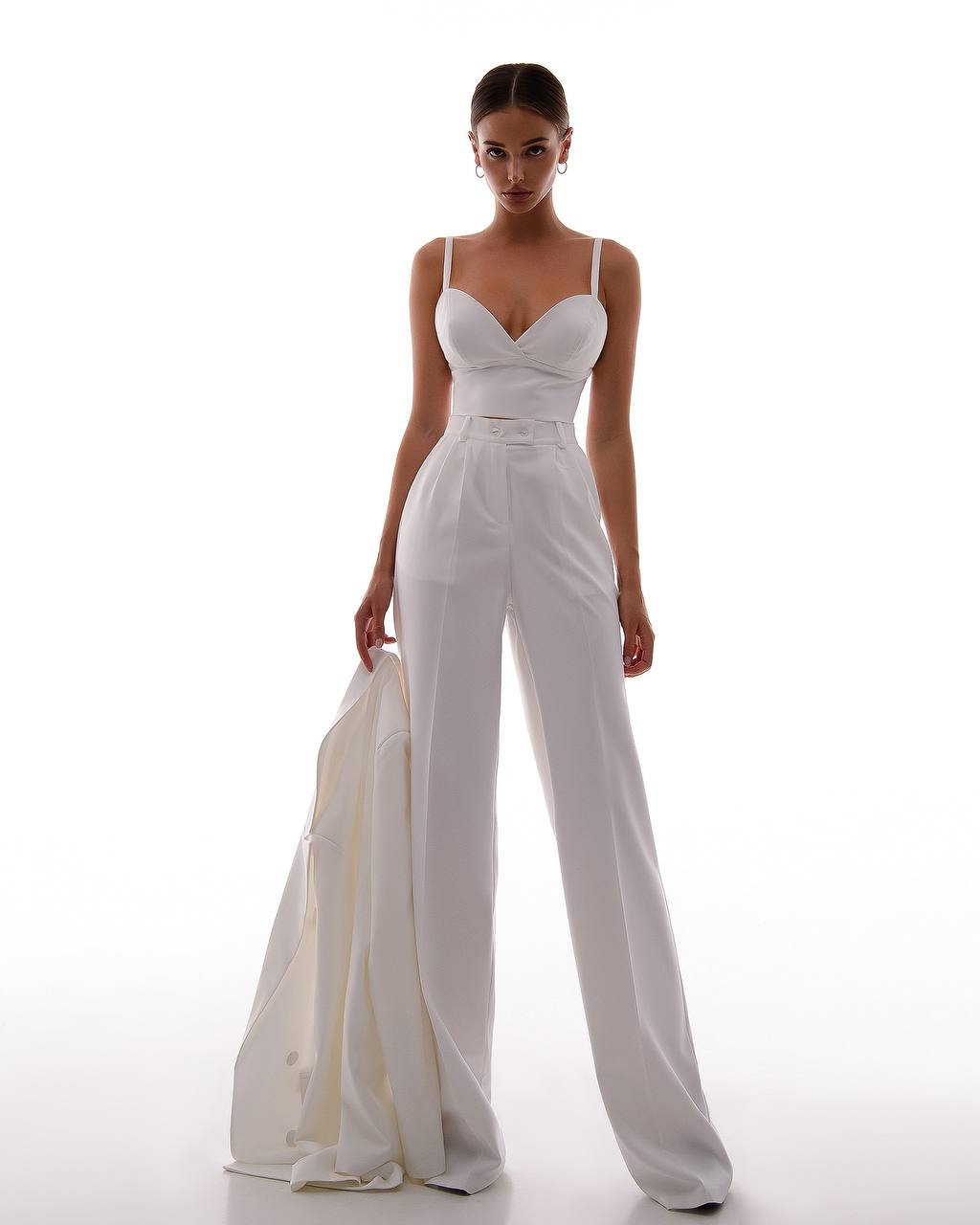 Woman wearing a white jumpsuit on a white background