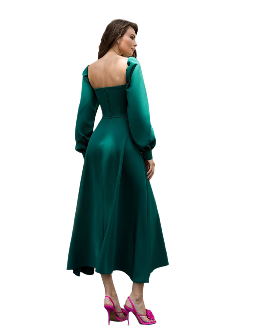 Woman wearing a green dress with a fitted bodice and flared skirt on a white background