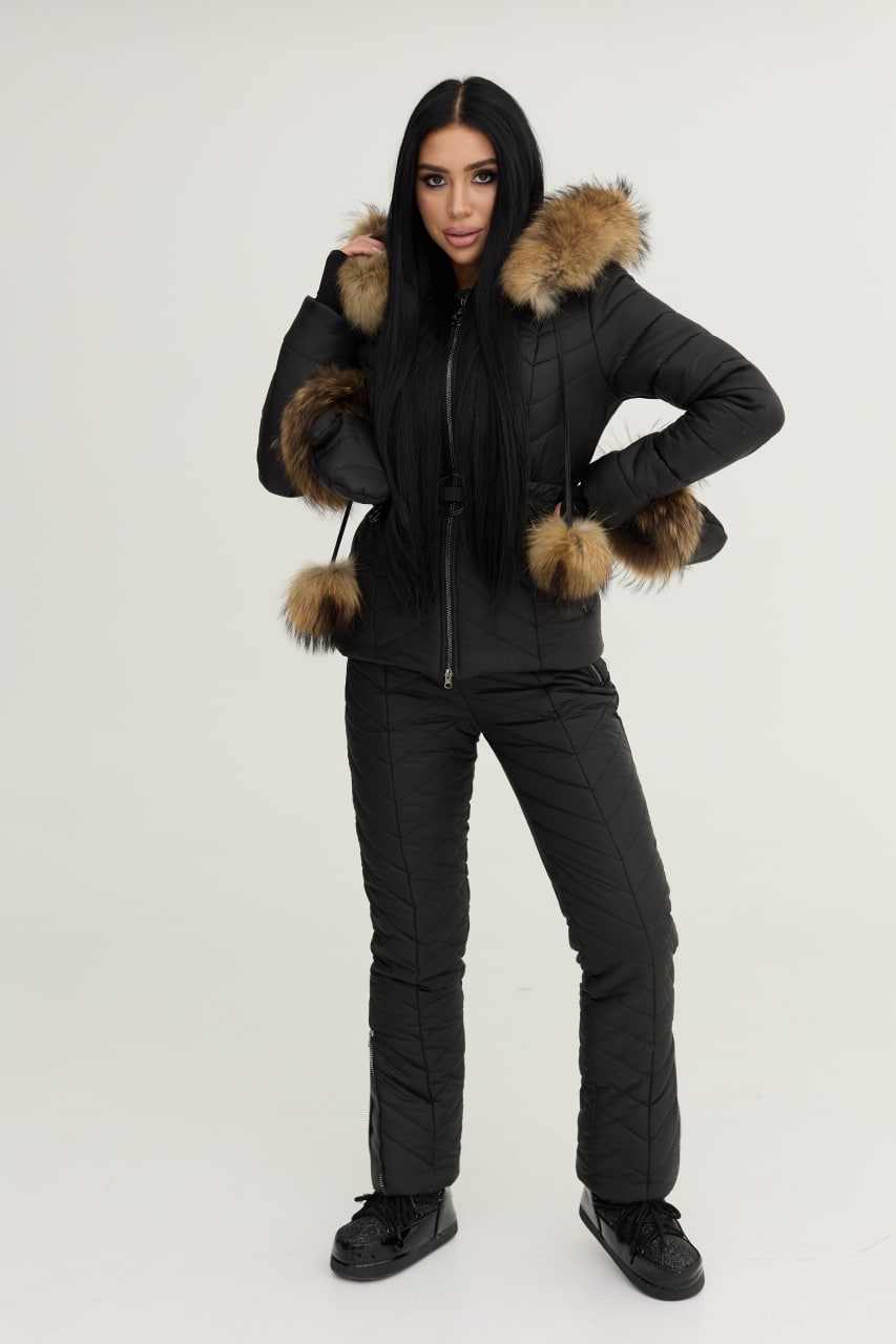 Person wearing a black puffer jacket with fur-lined hood on a white background