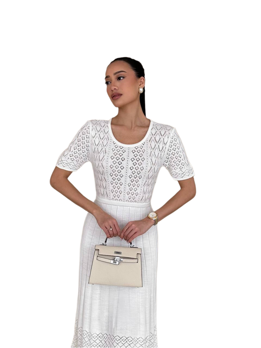 Woman wearing a white lace dress holding a beige handbag on a white background
