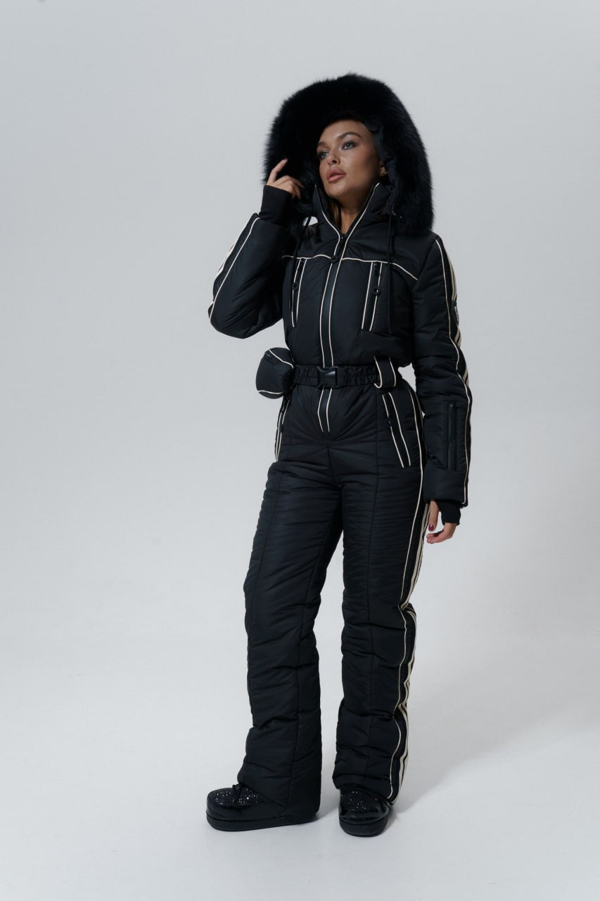 Person wearing a black snowsuit with a fur-lined hood on a white background