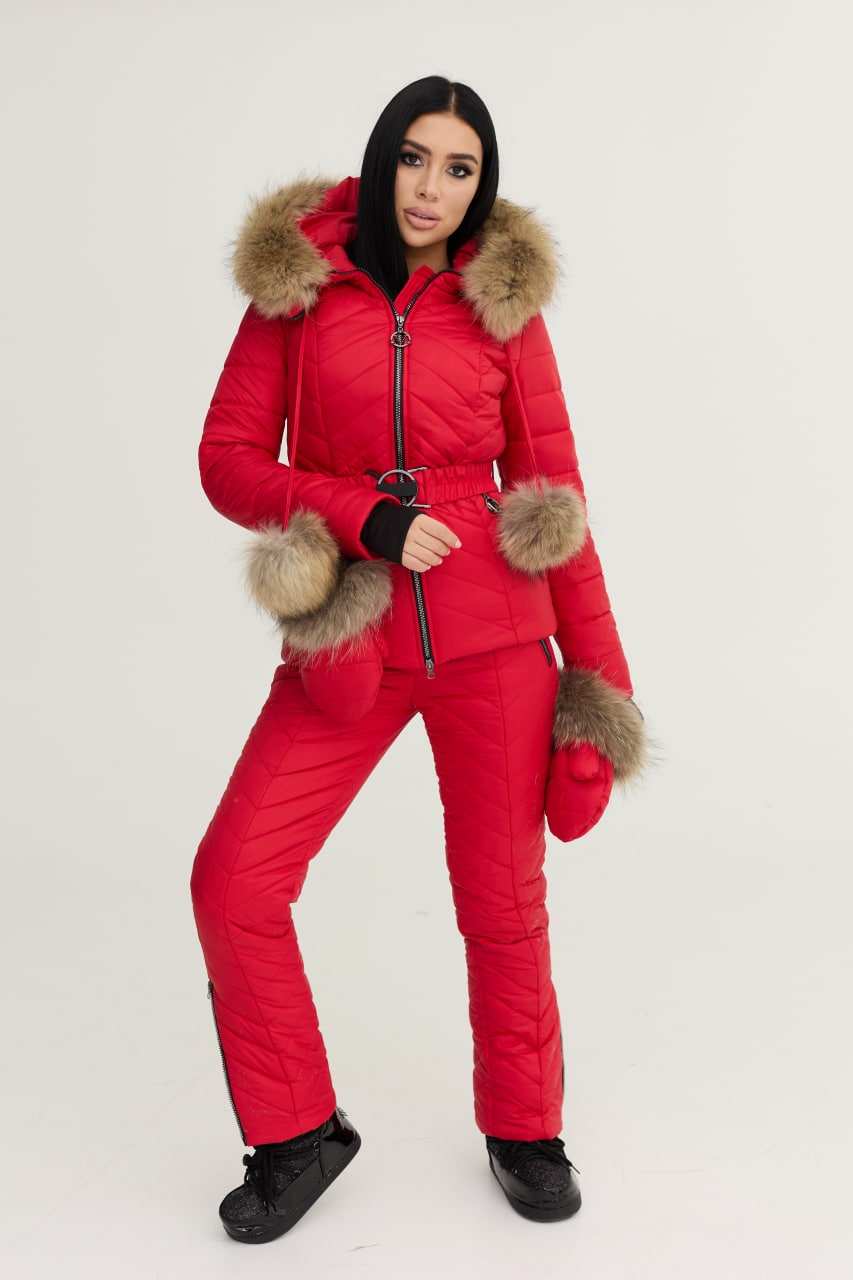 Person wearing a red puffer suit with fur trim on a white background