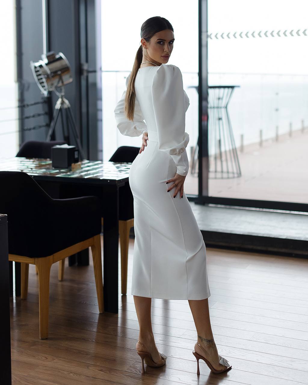 Woman in a white dress standing in a modern indoor setting