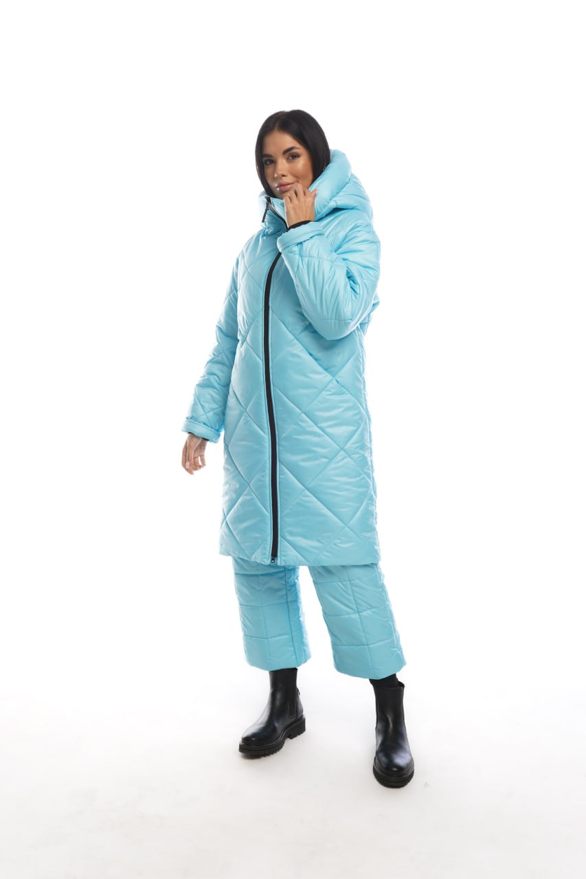 Person wearing a light blue puffer coat and pants on a white background