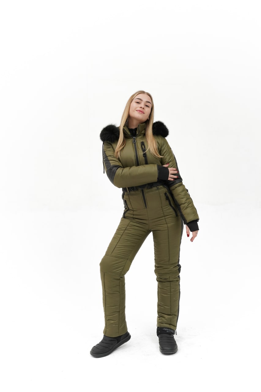 Person wearing a green winter suit with black fur trim on a white background