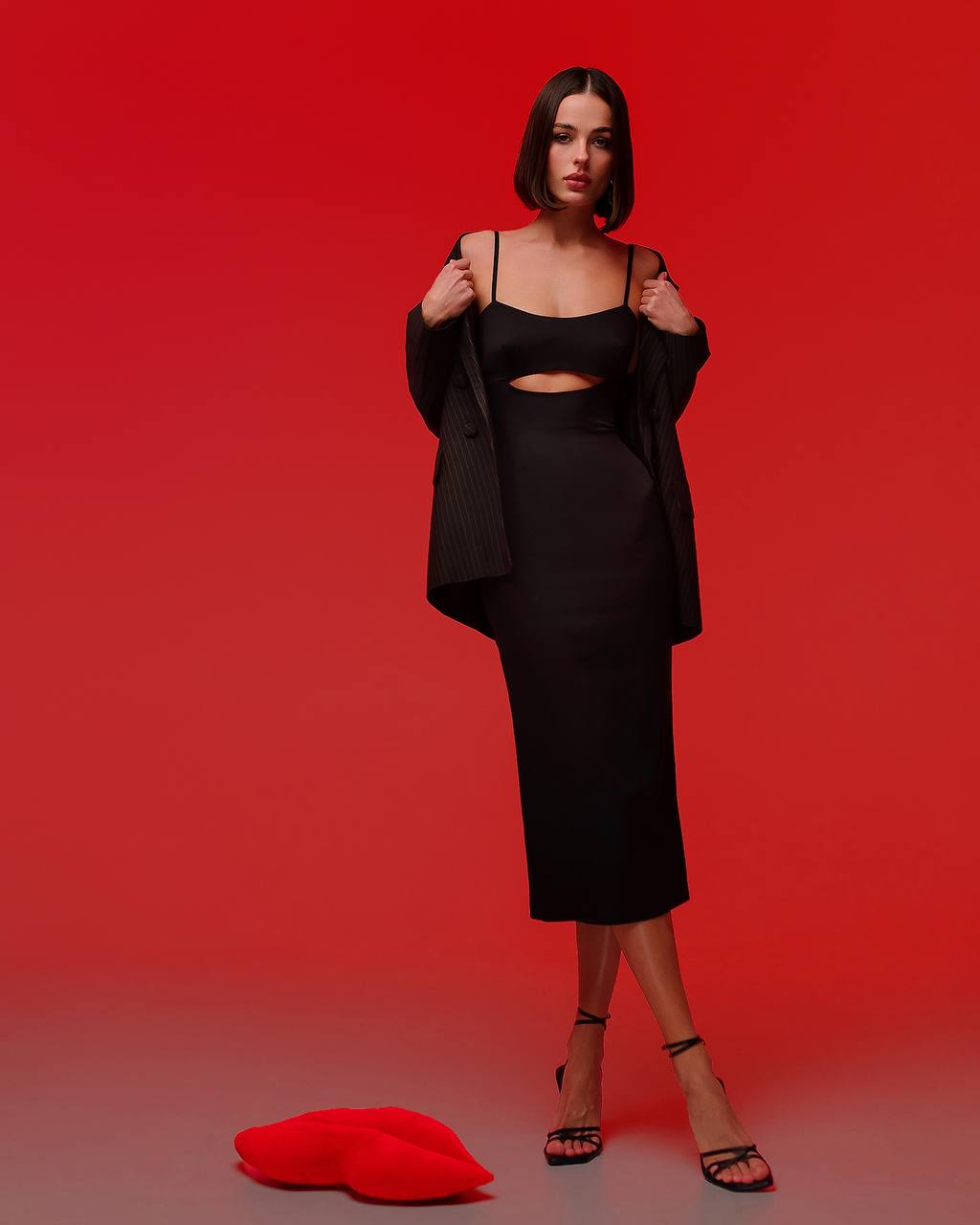 Woman wearing a black outfit against a red background