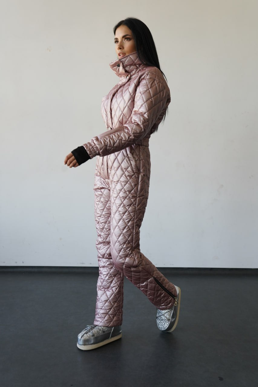 Person wearing a quilted pink snowsuit against a plain background