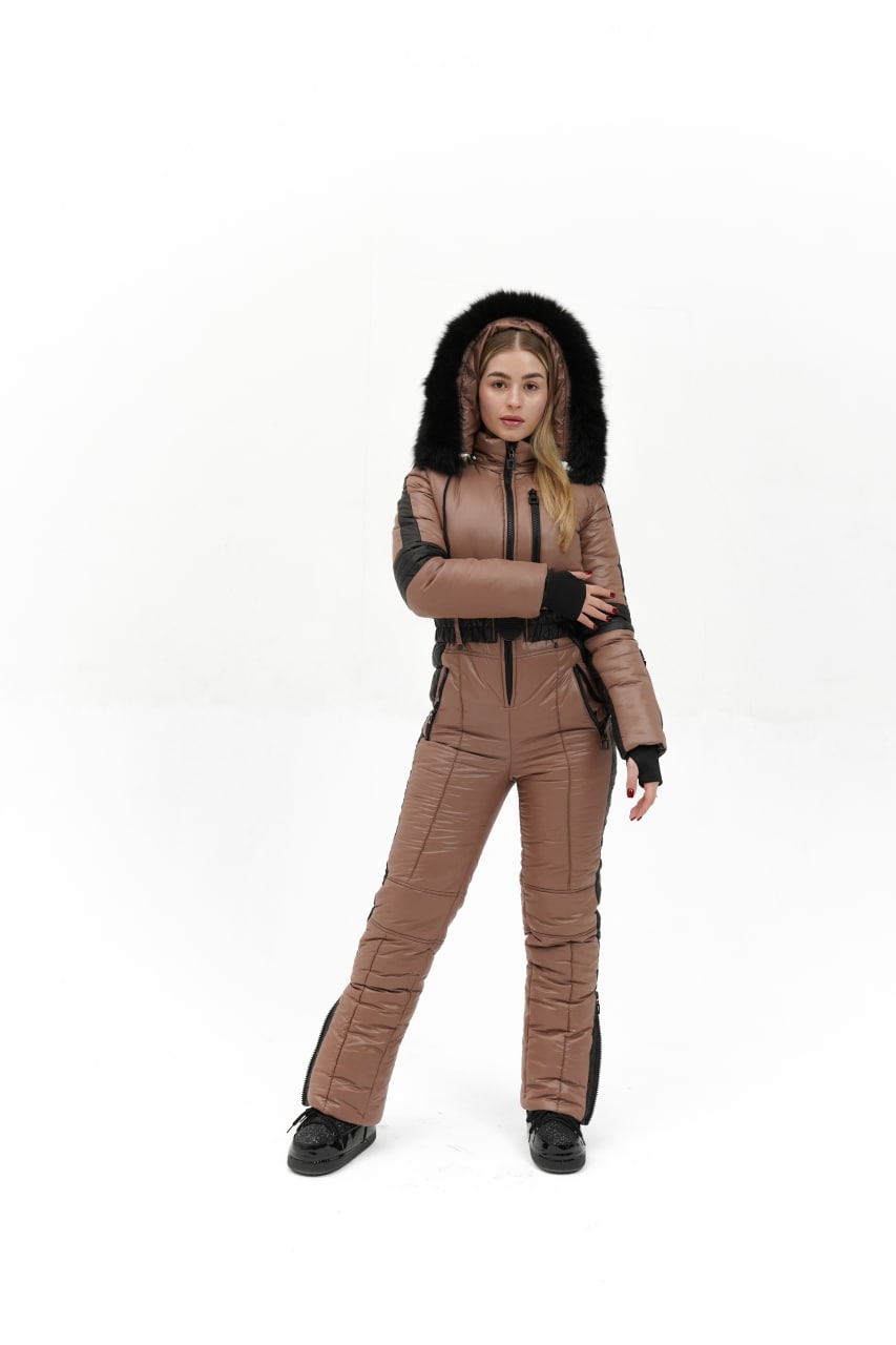 Person wearing a brown quilted jumpsuit with a hood on a white background
