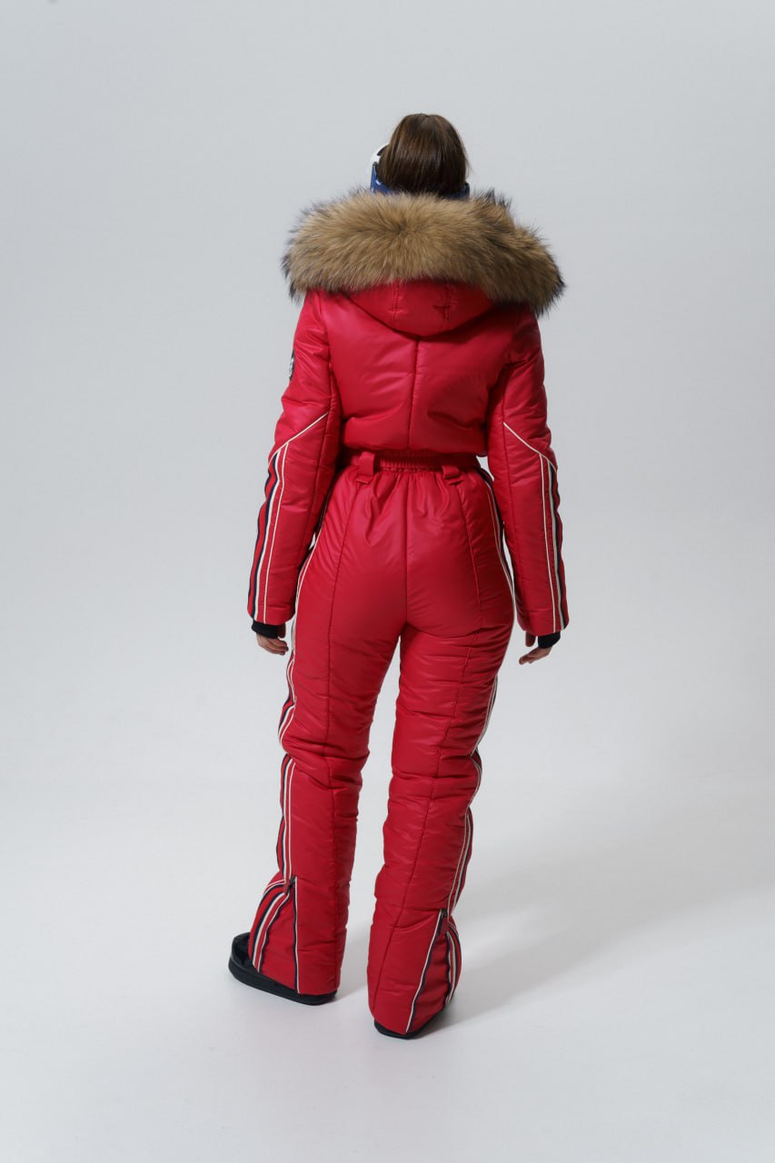 Person wearing a red ski suit with fur hood on a white background