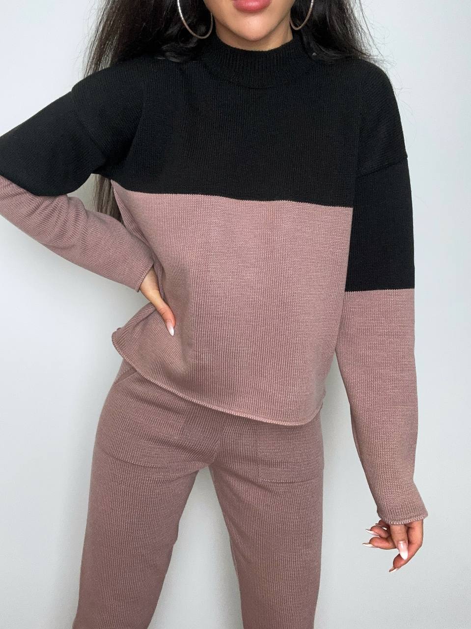 Two-tone black and pink sweater set on a plain background