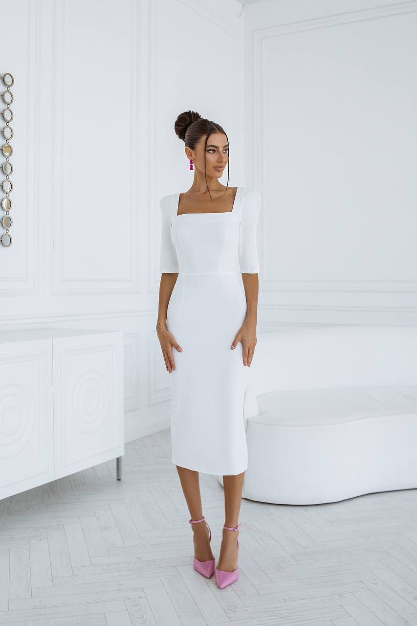 Woman wearing a white dress with a plain background