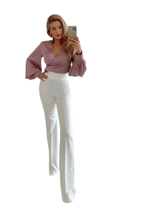 Woman wearing a mauve blouse and white pants on a white background