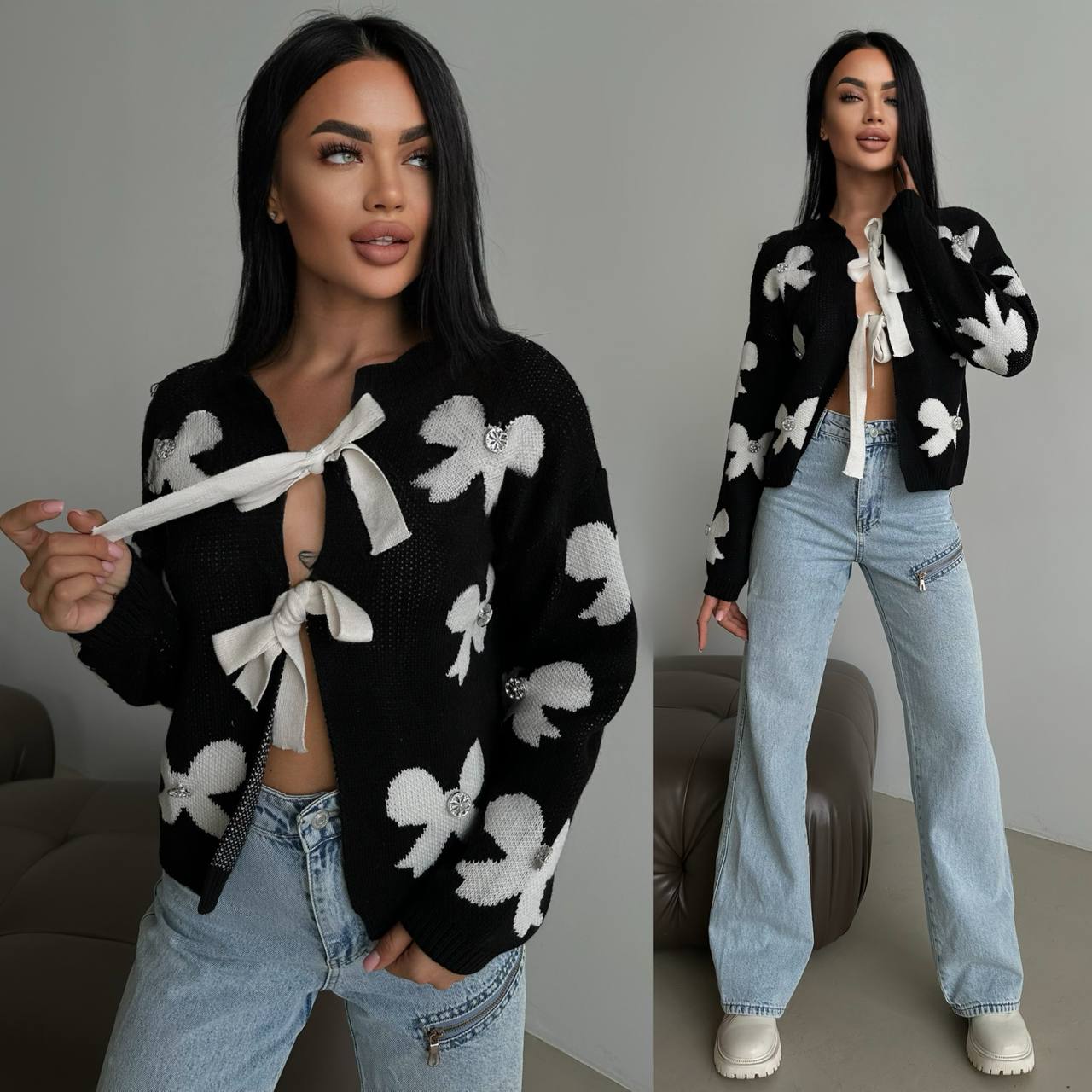 Woman wearing a black sweater with white bow patterns and light blue jeans, posing against a neutral background.