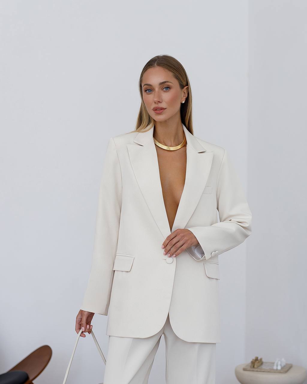 Woman wearing a white suit with a plain background