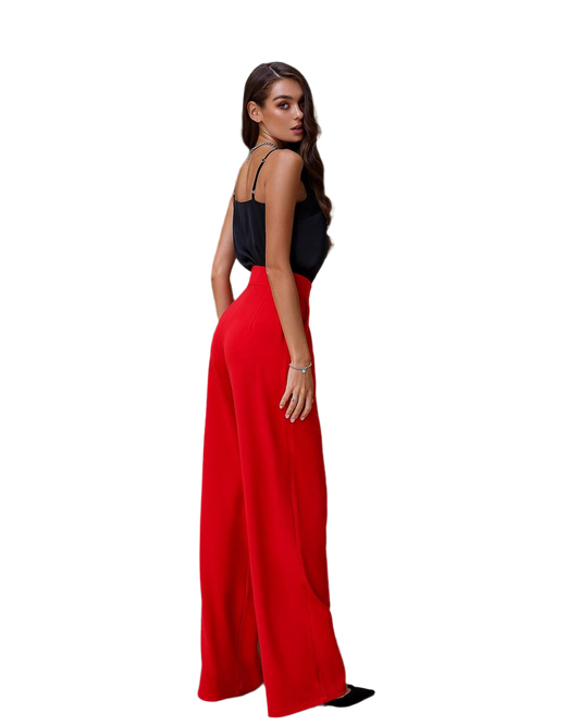 Woman wearing a black top and red wide-leg pants on a white background