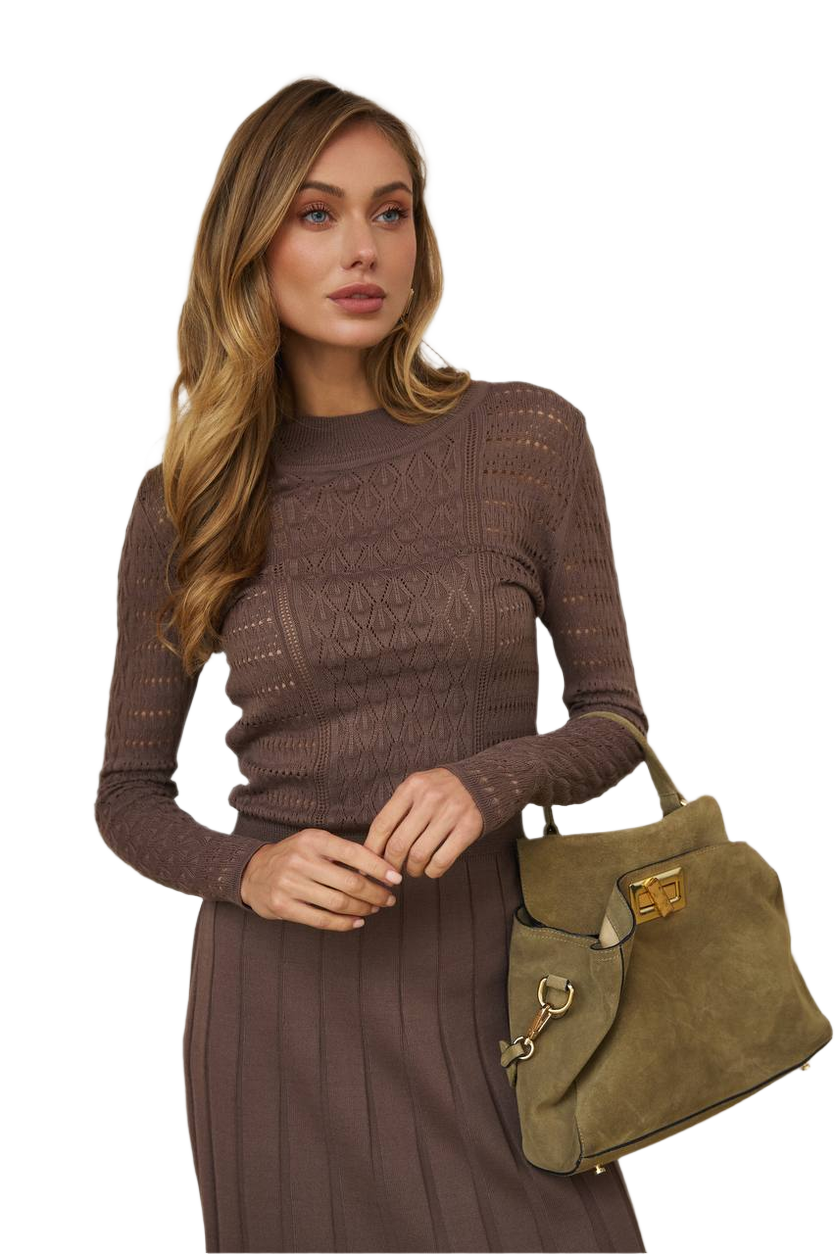 Woman holding a green handbag wearing a brown outfit on a white background