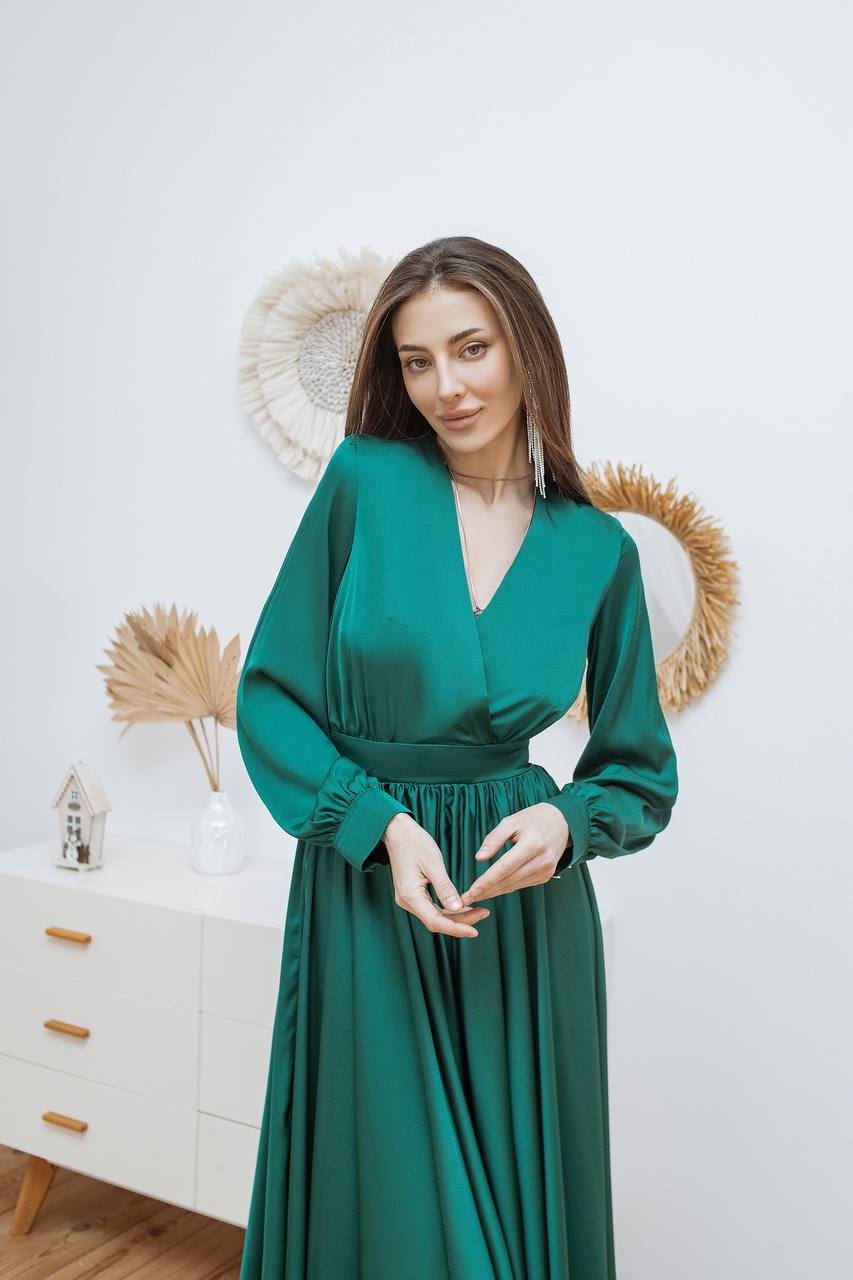 Woman wearing a green dress in a room with decorative elements.