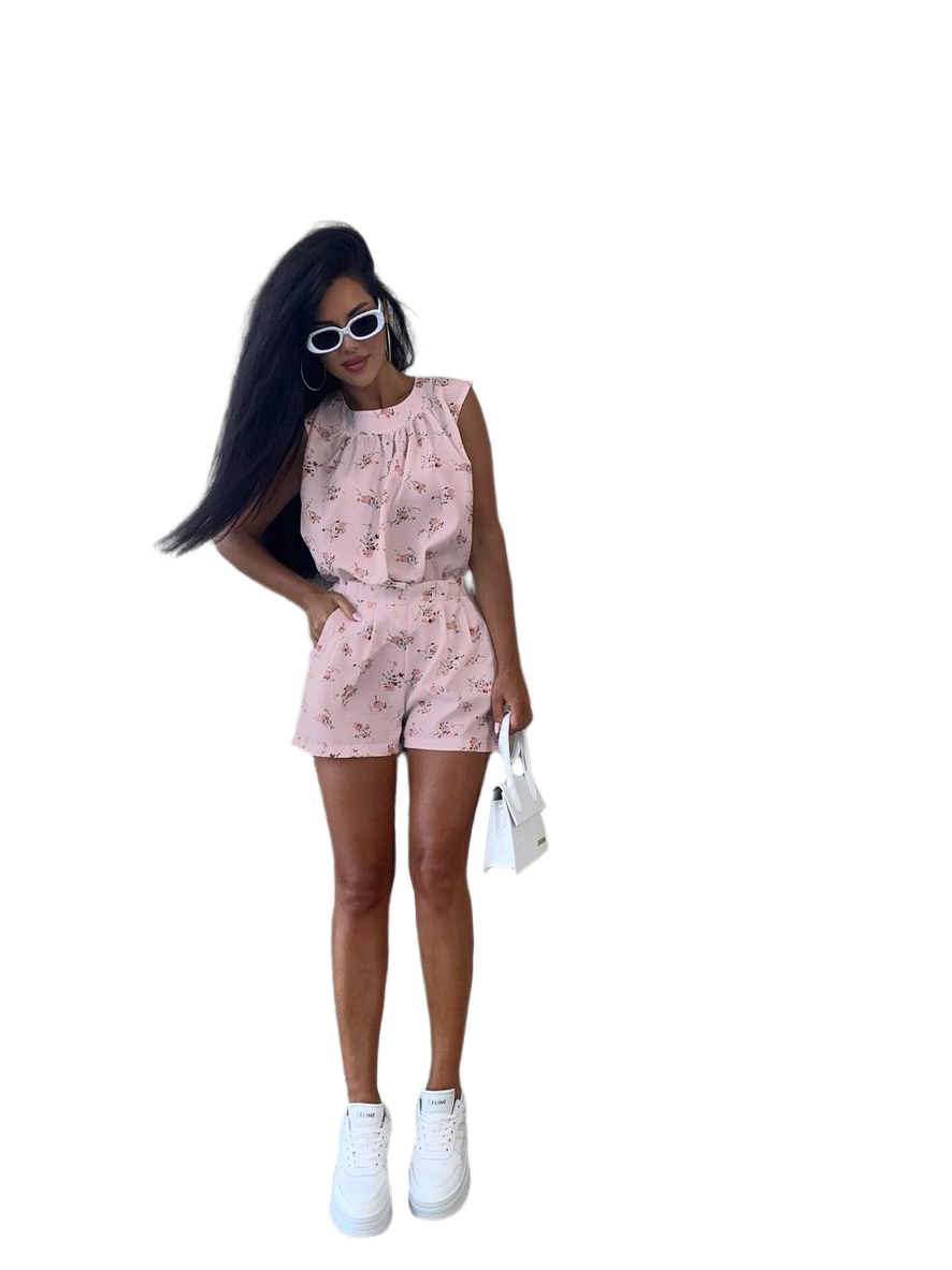 Woman wearing a pink floral romper on a white background