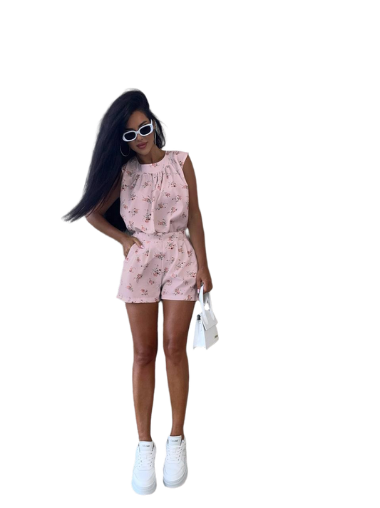 Woman wearing a pink floral romper on a white background