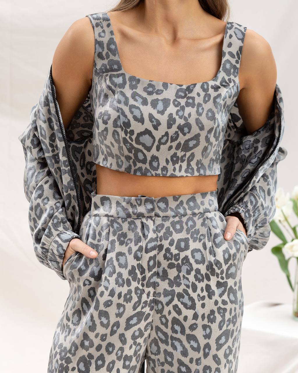 Person wearing a gray leopard print outfit with a matching cardigan.