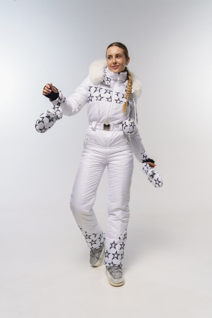 Person wearing a white snowsuit with star patterns on a light gray background