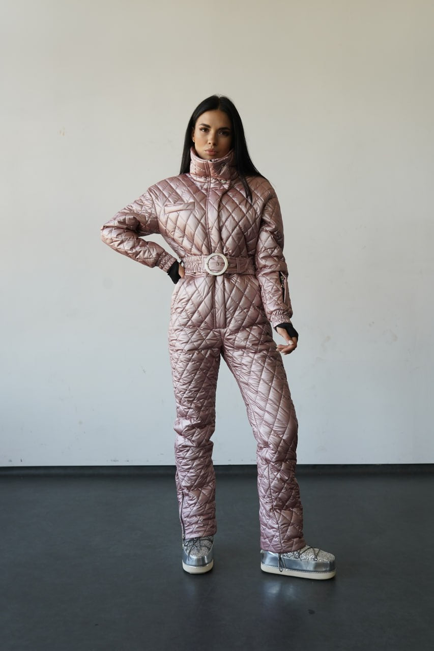 Person wearing a quilted pink snowsuit against a plain background