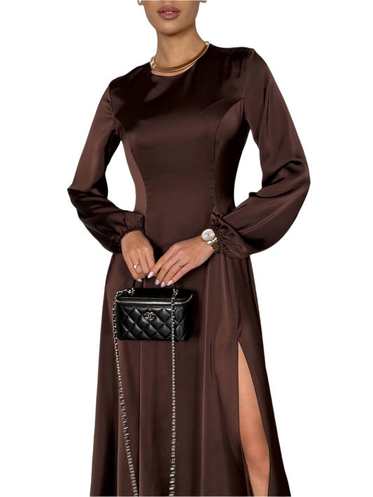 Woman wearing a brown dress holding a black handbag on a white background